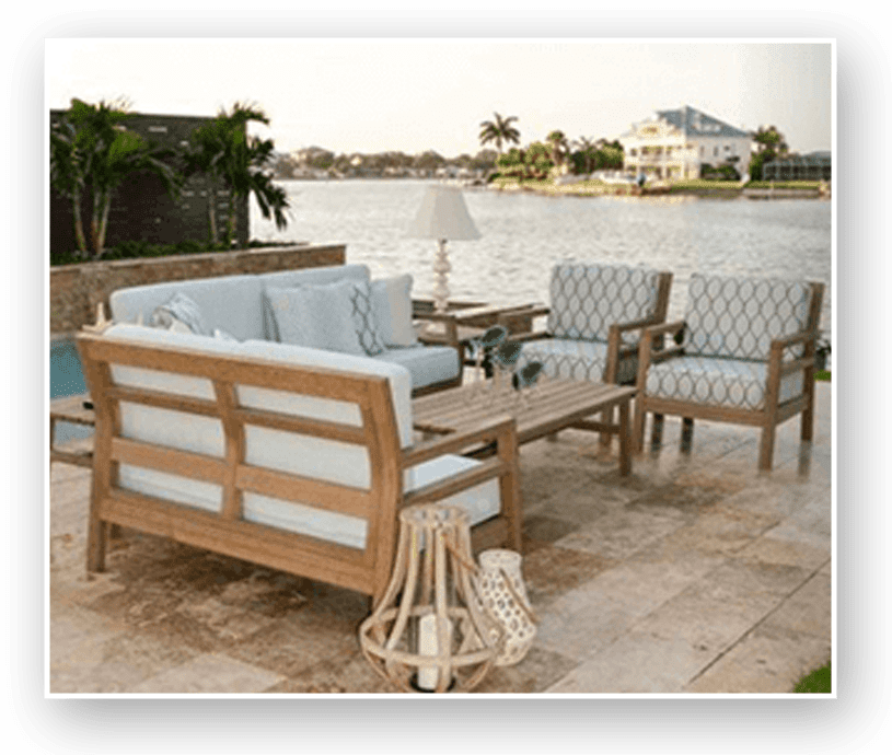 A patio with furniture and water in the background.